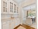 Butlers pantry with white cabinets and granite countertops leading into the dining room at 1728 Shadow Forest Dr, Matthews, NC 28105