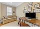 Cozy home office with a comfortable sofa, desk, and natural light from the window at 1728 Shadow Forest Dr, Matthews, NC 28105