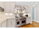 Modern kitchen features stainless steel range hood, gas stove and sleek countertops at 1728 Shadow Forest Dr, Matthews, NC 28105