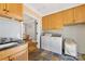Convenient laundry room featuring a washer, dryer, storage cabinets, and a sink with luxury stone tile flooring at 1728 Shadow Forest Dr, Matthews, NC 28105
