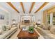 Bright living room with wooden beams, neutral furniture, and view to the kitchen at 1728 Shadow Forest Dr, Matthews, NC 28105