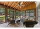 Enclosed sunroom with vaulted ceiling, wood floors and comfortable outdoor seating at 1728 Shadow Forest Dr, Matthews, NC 28105