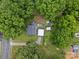 Aerial view of house with mature trees, landscaping, deck, backyard storage buildings, and carport at 206 Charlotte St, York, SC 29745