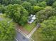 Aerial view of home showcasing the surrounding mature trees and landscaping with a storage building in the backyard at 206 Charlotte St, York, SC 29745