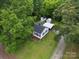 Home with mature trees and landscaping, showing backyard storage buildings and carport at 206 Charlotte St, York, SC 29745