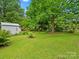 Lush backyard featuring mature trees, manicured landscaping and grassy lawn at 206 Charlotte St, York, SC 29745