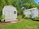 Backyard with white shed buildings surrounded by lush greenery and garden at 206 Charlotte St, York, SC 29745