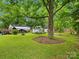 Serene backyard featuring mature trees, lush greenery, shed, and car port at 206 Charlotte St, York, SC 29745