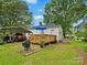 Large backyard featuring a deck, storage shed, car port and mature trees at 206 Charlotte St, York, SC 29745