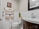 Compact bathroom with wainscoting, a dark wood vanity, and a decorative mirror at 206 Charlotte St, York, SC 29745