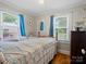 Cozy bedroom with two windows, wood floors, and a vintage-style bedspread at 206 Charlotte St, York, SC 29745