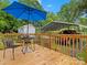 Relax on the deck with a table, chairs, and shade from a blue umbrella, car port and shed at 206 Charlotte St, York, SC 29745