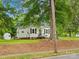 Charming home featuring vinyl siding, a well-maintained lawn, and mature trees providing shade and character at 206 Charlotte St, York, SC 29745