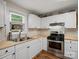Well-lit kitchen boasting stainless steel appliances, white cabinets, and a stylish backsplash at 206 Charlotte St, York, SC 29745