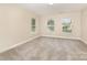 Neutral bedroom with three windows providing natural light and neutral carpet at 237 Lylic Woods Dr, Fort Mill, SC 29715
