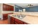Stainless steel kitchen sink with cherry wood cabinets and a view to the living area at 237 Lylic Woods Dr, Fort Mill, SC 29715