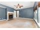 Spacious living room featuring a cozy fireplace, ceiling fan and natural light from the windows at 237 Lylic Woods Dr, Fort Mill, SC 29715