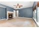Spacious living room featuring a cozy fireplace, ceiling fan and natural light from the windows at 237 Lylic Woods Dr, Fort Mill, SC 29715