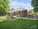 Brick home with a patio, furniture, and meticulously maintained backyard at 2616 Carmarthen Ct, Matthews, NC 28104