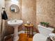 Chic powder room featuring a pedestal sink, decorative wallpaper, and hardwood flooring at 2616 Carmarthen Ct, Matthews, NC 28104
