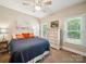 Comfortable bedroom with a ceiling fan, large windows, and stylish decor at 2616 Carmarthen Ct, Matthews, NC 28104