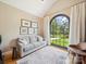 Bright living room features a comfortable sofa, unique windows, and calming decor at 2616 Carmarthen Ct, Matthews, NC 28104