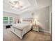 Spacious main bedroom featuring plush carpeting, decorative ceiling, and a stylish white bed frame at 2616 Carmarthen Ct, Matthews, NC 28104