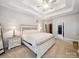 Bright main bedroom with large windows, plush carpet, and an ensuite bath with doors visible beyond at 2616 Carmarthen Ct, Matthews, NC 28104