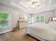 Bright main bedroom with a trey ceiling, ceiling fan, and large windows with a view to the backyard at 2616 Carmarthen Ct, Matthews, NC 28104