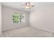 Bright bedroom featuring a ceiling fan and a window with backyard views at 3008 Cornflower Ln, Indian Trail, NC 28079