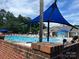 Community pool with blue sunshades, brick accents, and lounge chairs offers a great recreational space at 3008 Cornflower Ln, Indian Trail, NC 28079