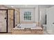 Modern bathroom featuring a separate shower and soaking tub with tile surround and natural light at 3830 Waters Reach Ln, Indian Trail, NC 28079