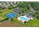 Aerial view of the community pool, tennis courts and amenity center in a wooded surrounding at 3830 Waters Reach Ln, Indian Trail, NC 28079