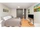 Comfortable bedroom with hardwood floors, sports-themed art, and a closet with sliding mirror doors at 4014 Sulkirk Rd, Charlotte, NC 28210