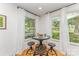 Bright dining area featuring an industrial table set between large windows with hanging curtains at 4014 Sulkirk Rd, Charlotte, NC 28210