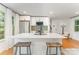 Open kitchen with white cabinets, island with seating, and stainless steel appliances at 4014 Sulkirk Rd, Charlotte, NC 28210