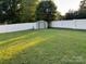 A backyard with a white fence surrounding the perimeter and a shed in the back at 407 W Mill St, Landis, NC 28088