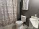 Bathroom featuring a standard toilet, sink, and shower with curtain at 407 W Mill St, Landis, NC 28088