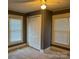 Carpeted bedroom featuring a ceiling fan, closet, and two windows at 407 W Mill St, Landis, NC 28088