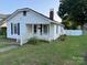 Quaint single-story home featuring white siding, black shutters and a well-kept front yard at 407 W Mill St, Landis, NC 28088
