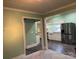 Open living area featuring wood-look floors, stainless steel refrigerator, and view into the kitchen at 407 W Mill St, Landis, NC 28088