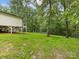 Expansive backyard featuring a gentle slope, bordered by a fenced perimeter, and the home on stilts at 5322 Bridgeview Dr, Iron Station, NC 28080