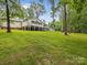 Lush backyard with mature trees framing the home's architecture, set against a green lawn at 5322 Bridgeview Dr, Iron Station, NC 28080