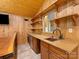 Basement bar featuring custom wood paneling, granite countertops, and beverage refrigerator at 5322 Bridgeview Dr, Iron Station, NC 28080