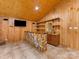 Basement bar featuring custom wood paneling, tiled floors, and ample shelving for storage at 5322 Bridgeview Dr, Iron Station, NC 28080