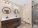 Elegant bathroom with double vanity, modern lighting, and a separate toilet area at 5322 Bridgeview Dr, Iron Station, NC 28080