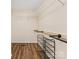 Functional walk-in closet with storage shelves, hanging rods and sleek dark laminate flooring at 5322 Bridgeview Dr, Iron Station, NC 28080