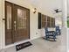 Covered porch boasts rocking chairs and decorative front door at 5322 Bridgeview Dr, Iron Station, NC 28080