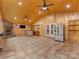 Spacious living room with wood-paneled walls, a fireplace, bar area, and stainless steel refrigerator at 5322 Bridgeview Dr, Iron Station, NC 28080