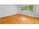 Bright living room with hardwood floors and a large window overlooking the front yard at 5322 Bridgeview Dr, Iron Station, NC 28080